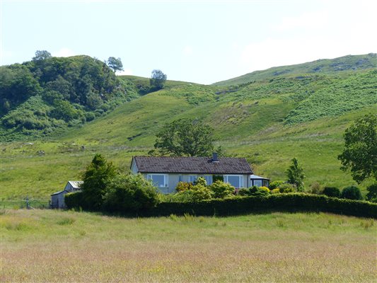 holiday cottage in the countryside with green hill behind